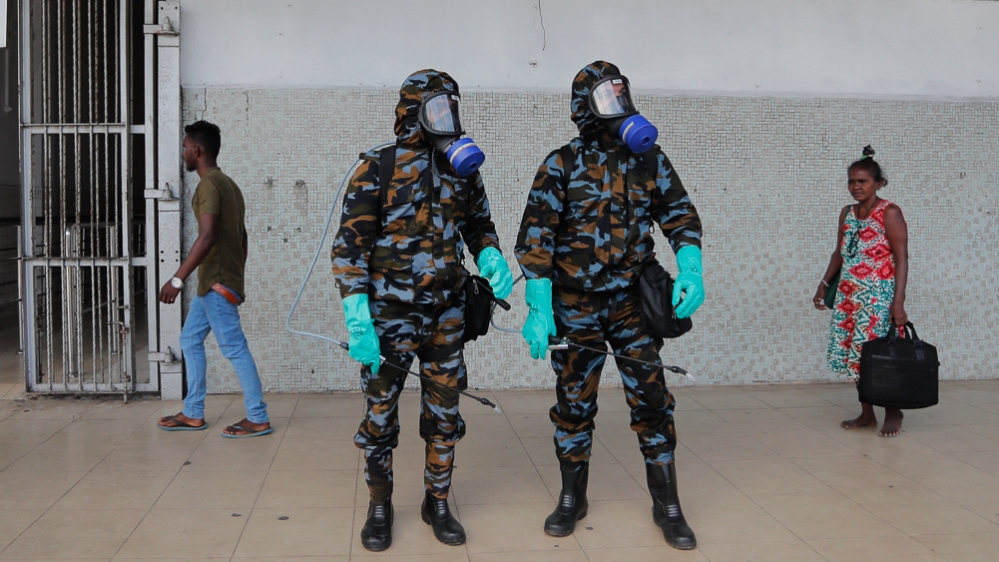 Sri Lankan government soldiers in protective clothes prepare to spray disinfectant inside a railway station in Colombo, Sri Lanka, Wednesday, March 18, 2020. For most people, the new coronavirus cause