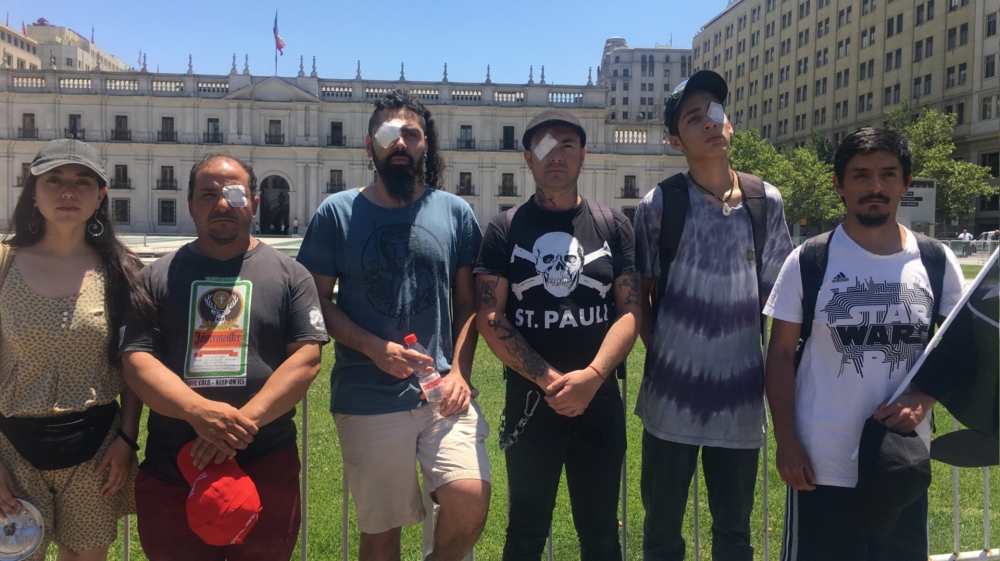 Those who have suffered eye injuries at the hands of police demonstrate outside La Moneda, the seat of the presidency