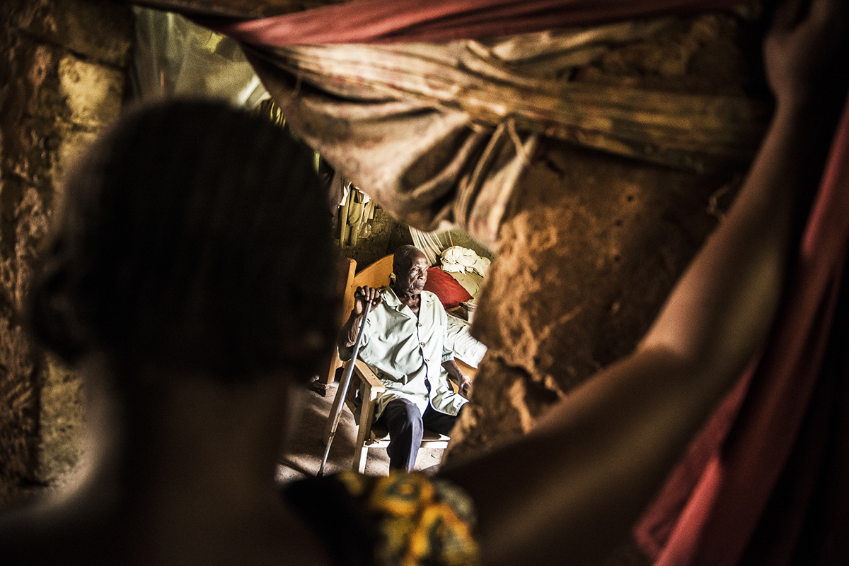 Kamer Gabriel, accused of witchcraft, in his house in Bangui, observed by one of his nephews. Mr Kamer is accused of witchcraft. The accusation came as a result of his age. Since the accusation was mo