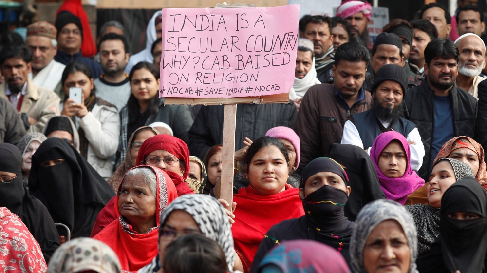 A demonstrator carries a sign during a protest against a new citizenship bill in New Delhi, India December 22, 2019. REUTERS/Adnan Abidi