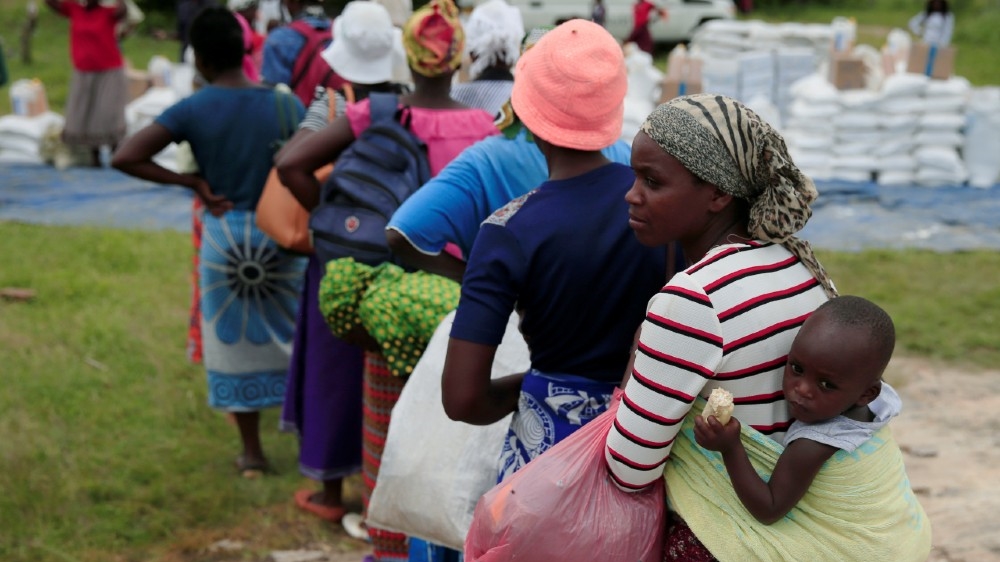 Villagers queue to collect food aid distributed by the World Food Program (WFP) following a prolonged drought in rural Mudzi district, Zimbabwe, February 20, 2020.