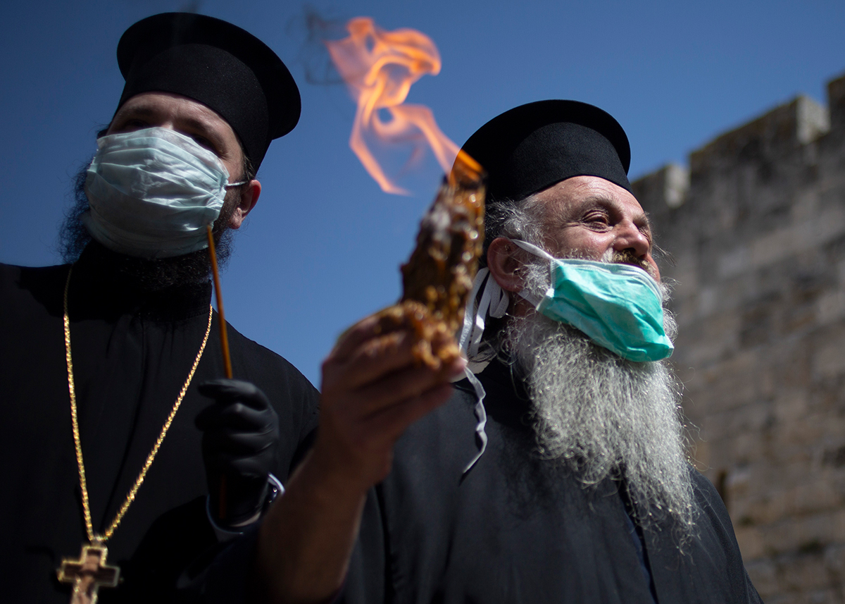Orthodox clergyman holds holy fire to transfer to predominantly Orthodox countries from the Church of the Holy Sepulchre, traditionally believed by many Christians to be the site of the crucifixion an