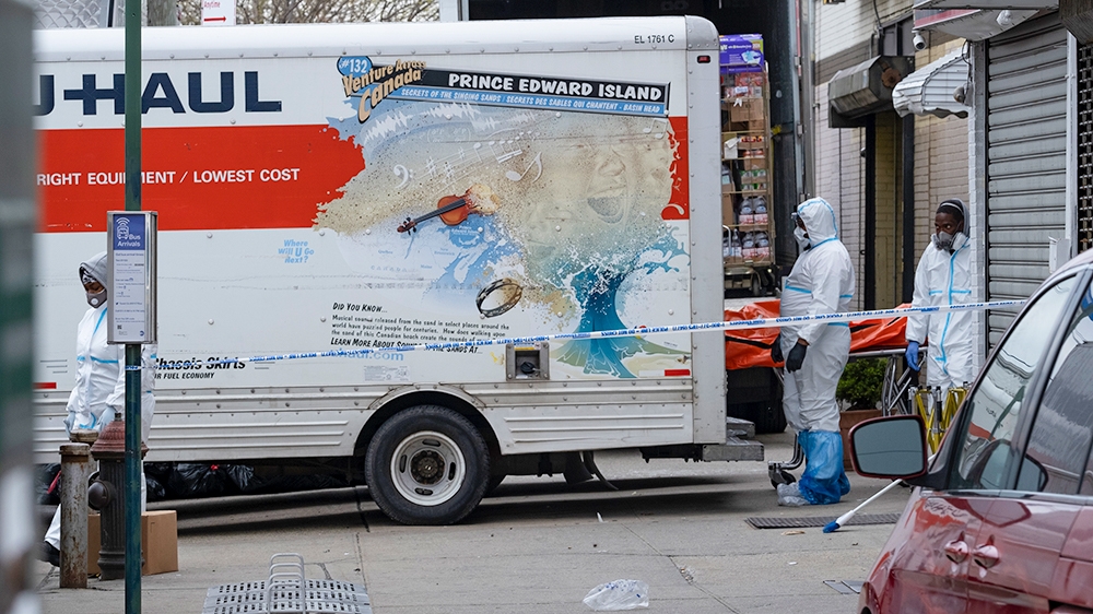 Workers move a body near the Andrew T. Cleckley Funeral Home in the Brooklyn borough of New York, Wednesday, April 29, 2020. Police responded to a report of human bodies in vehicles, which they determ