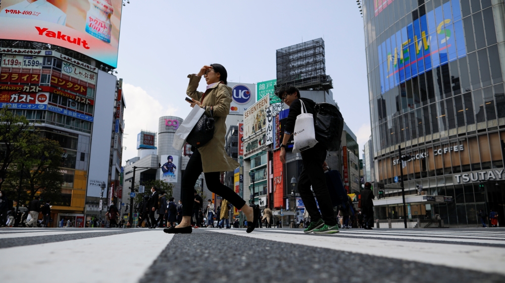 Less than usual pedestrians cross the Shibuya crossing after the government announced the state of emergency for the capital following the coronavirus disease outbreak in Tokyo, Japan