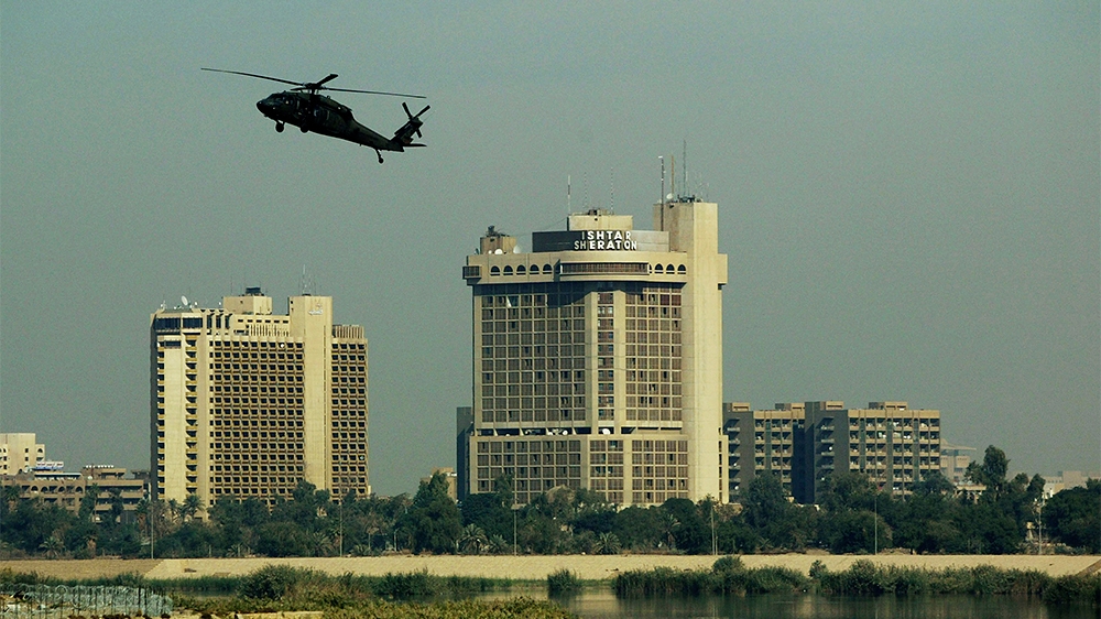 A Blackhawk helicopter flies near the Sheraton and Palestine hotels November 24, 2003 in Baghdad, Iraq. On April 8, 2003, two journalists were killed when an American tank fired a shell at the Palestine hotel, where many journalists were staying at the time