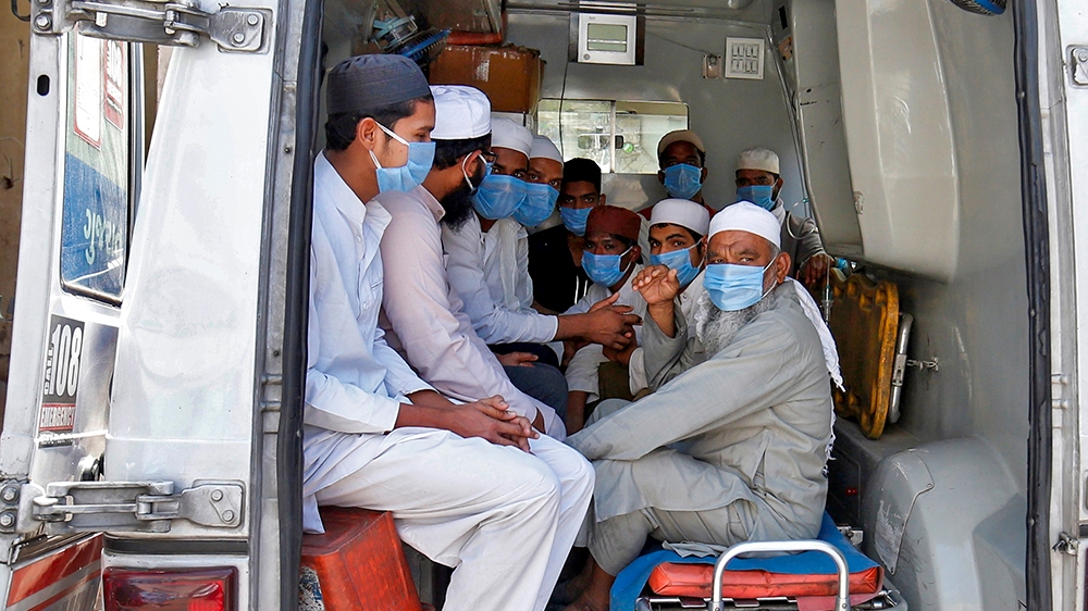 Men, who according to health and police officials had visited three Muslim missionary gatherings including in Nizamuddin area of New Delhi, wearing protective masks sit in an ambulance that will take