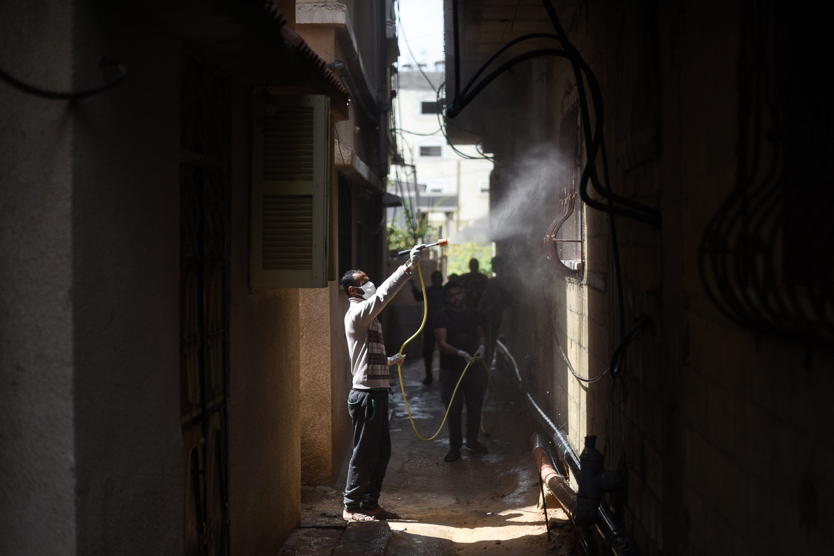 A volunteer disinfects buildings in the village of Khuza’a using a mixture of chlorine and water.