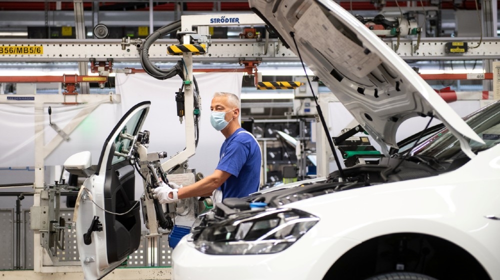 A worker wears a protective mask at the Volkswagen assembly line after VW re-starts Europe's largest car factory after coronavirus shutdown in Wolfsburg, Germany,