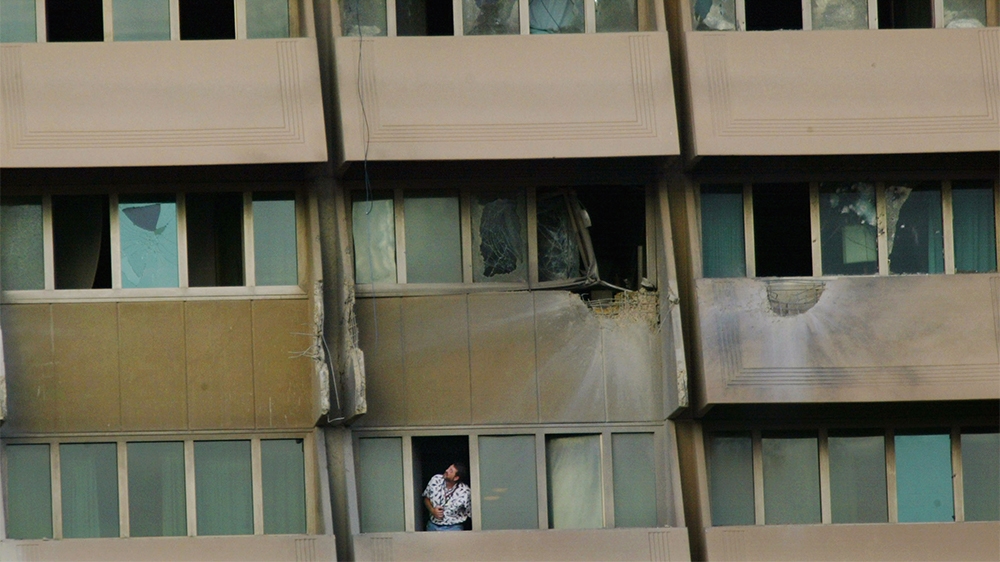 A man looks out of his hotel room after rockets were fired at the Al Rasheed Hotel in Bahdad on October 26, 2003. The hotel housed senior US military and civilian officials at the time. It had gained fame during the first Gulf War when CNN aired its newscasts from the hotel. After that war, a tile mosaic depicting US President George H.W. Bush was installed on the floor of the lobby so that visitors would have to walk over his face. It was smashed by American soldiers following the US invasion in 2003 and the hotel was converted into a base for the US military