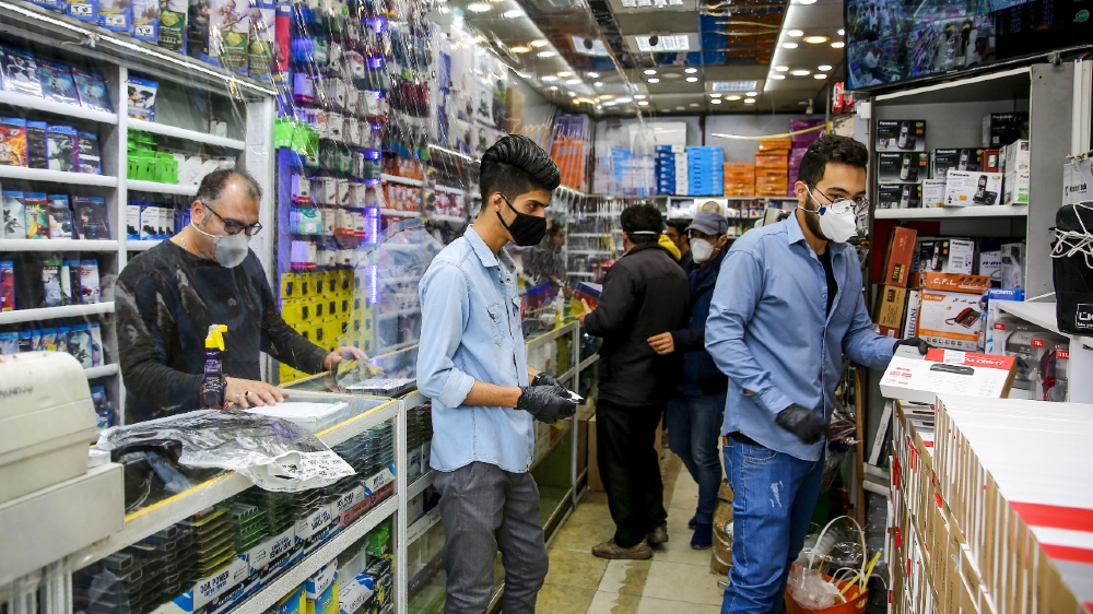 IRAN-HEALTH-VIRUS  Iranian men, wearing personal protective equipment, are pictured at an electronics shop in Mashhad on April 11, 2020, amid the coronavirus (COVID-19) pandemic. 