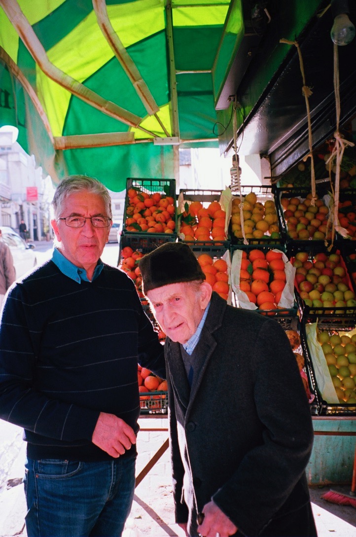 Nora’s father and grandfather at the neighbourhood fruit stand in Algiers [Photo courtesy of Nora Belblidia]