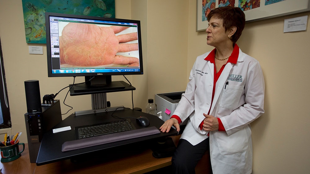University of Miami dermatologist Dr Anne Burdick checks the computer screen in her Miami office, as she discusses telemedicine