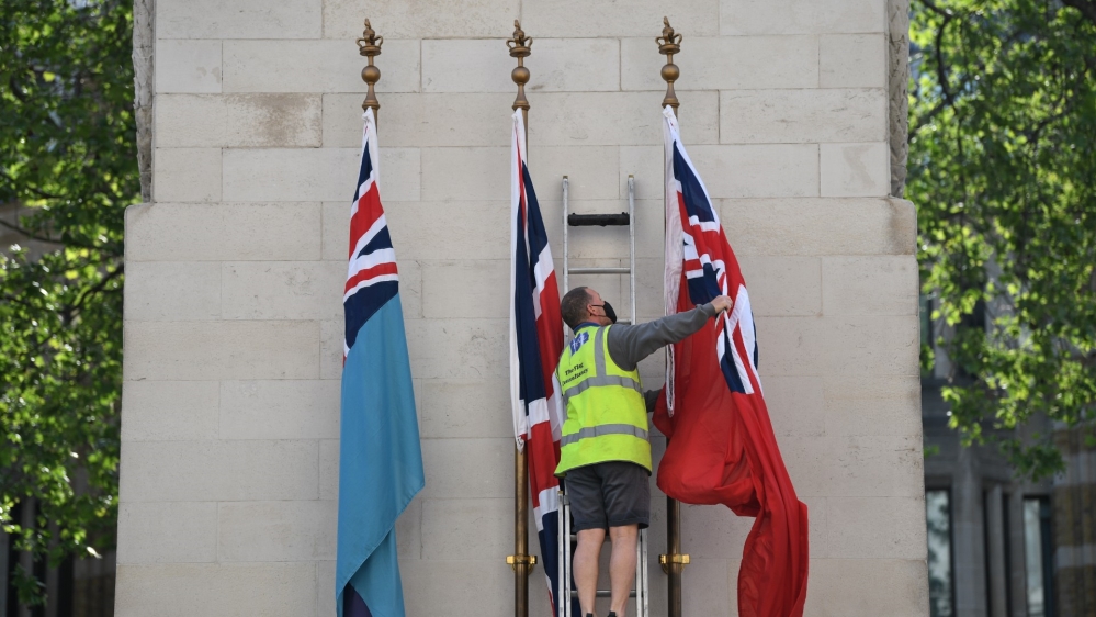 A contractor puts fresh flags on the Cenotaph war memorial on Whitehall in central London