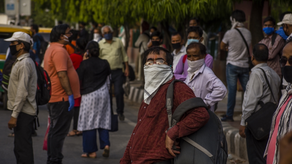 Commuters wait for vehicles, as the country relaxed its lockdown restrictions on May 26 in Delhi, India