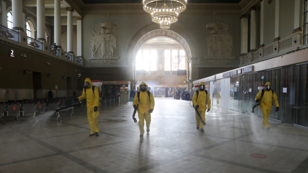 Russian emergency staff wearing personal protective equipment (PPE) spray disinfectant while sanitising the Kievsky Railway Station in Moscow