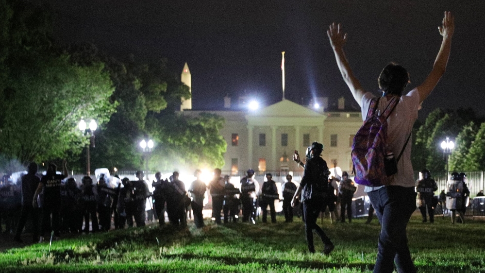 A protester holds his hands up as police officers enter Lafayette Park as the officers keep demonstrators away from the White House during a protest in Washington, DC, US, on May 30, 2020