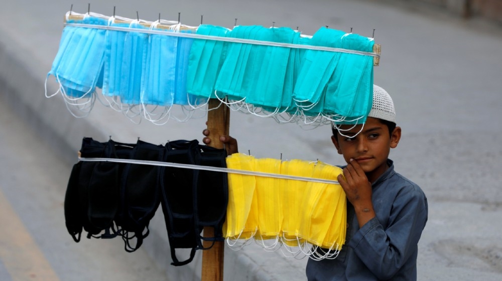 A boy waits for customers to sell handmade masks, after Pakistan started easing the coronavirus disease (COVID-19) lockdown, in Peshawar May 13, 2020. REUTERS/Fayaz Aziz