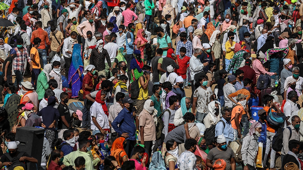 epa08436058 Indian migrant laborers queue for busses organized by the Brihanmumbai Municipal Corporation to get them to the Boriwali railway station where they can catch trains to their home villages,