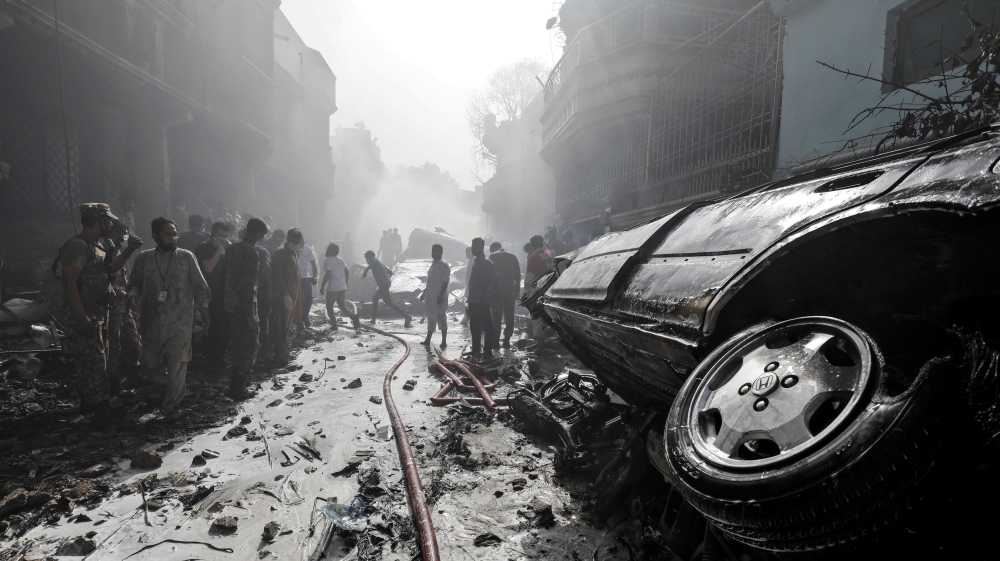 Rescue workers gather at the site of a passenger plane crash in a residential area near an airport in Karachi