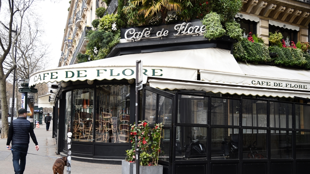 A man walks past the closed Cafe de Flore