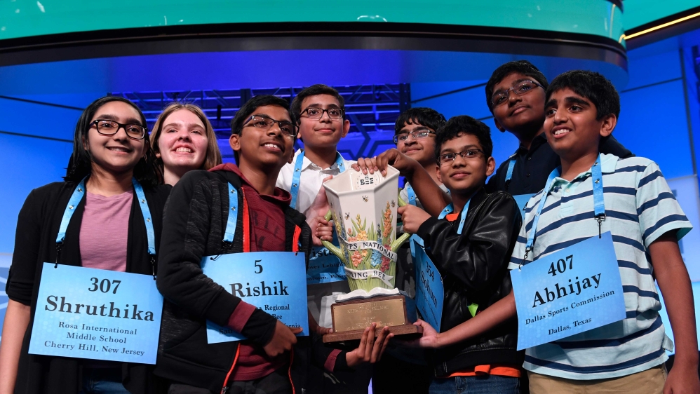 Eight cochampions carrying a trophy after winning the 2019 Scripps National Spelling Bee last year in Oxon Hill, Maryland