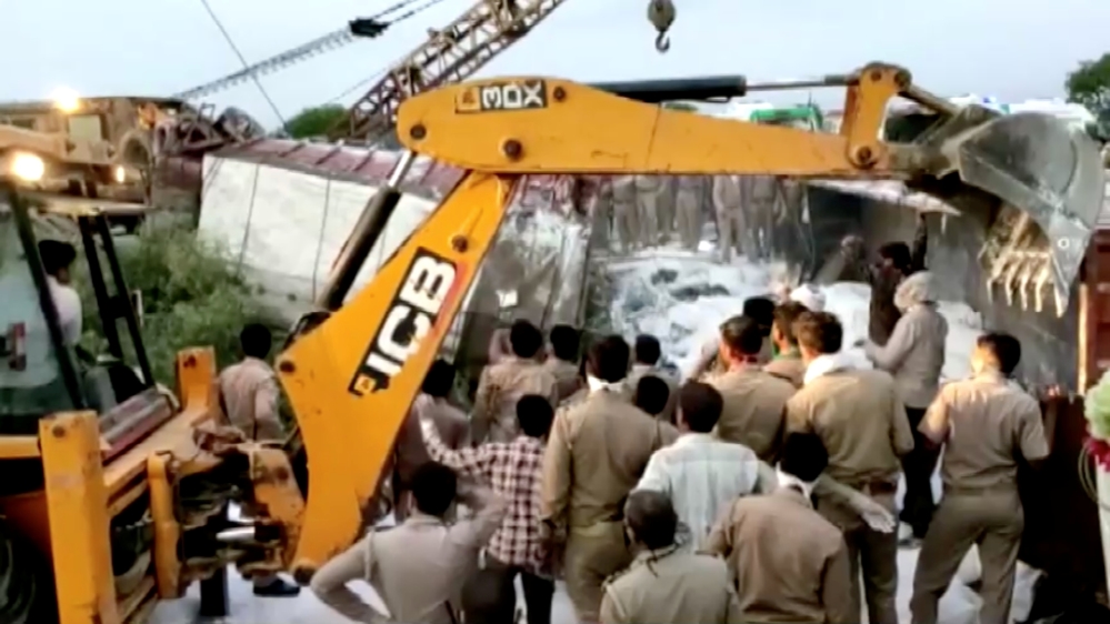 In this still image taken from video, a police rescue team works to lift a truck at the site of an accident in Auraiya, Uttar Pradesh, India, on May 16, 2020 [ANI via Reuters]