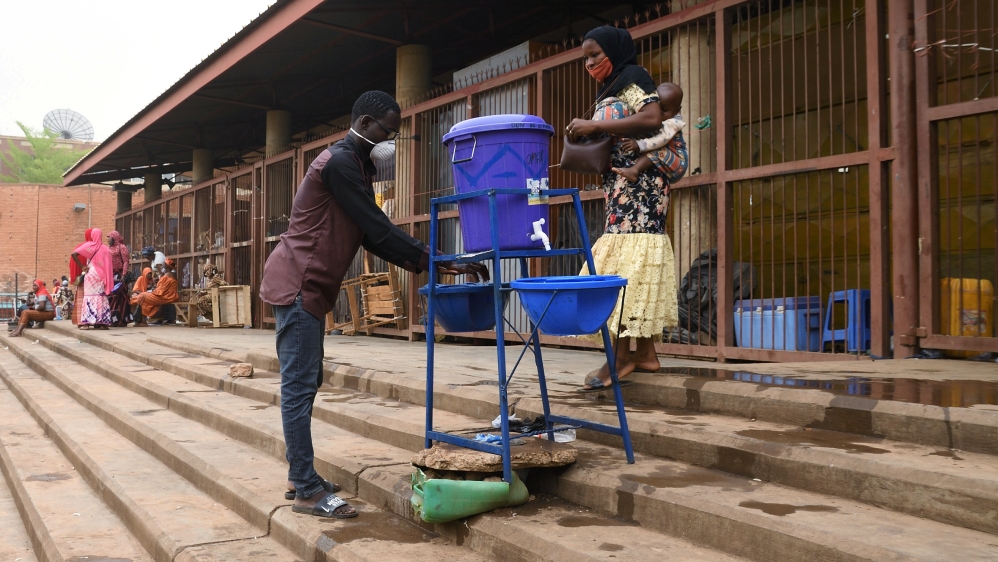 A man washes his hands before entering reopened Rood-Wooko city central market, in Ouagadougou, Burkina Faso