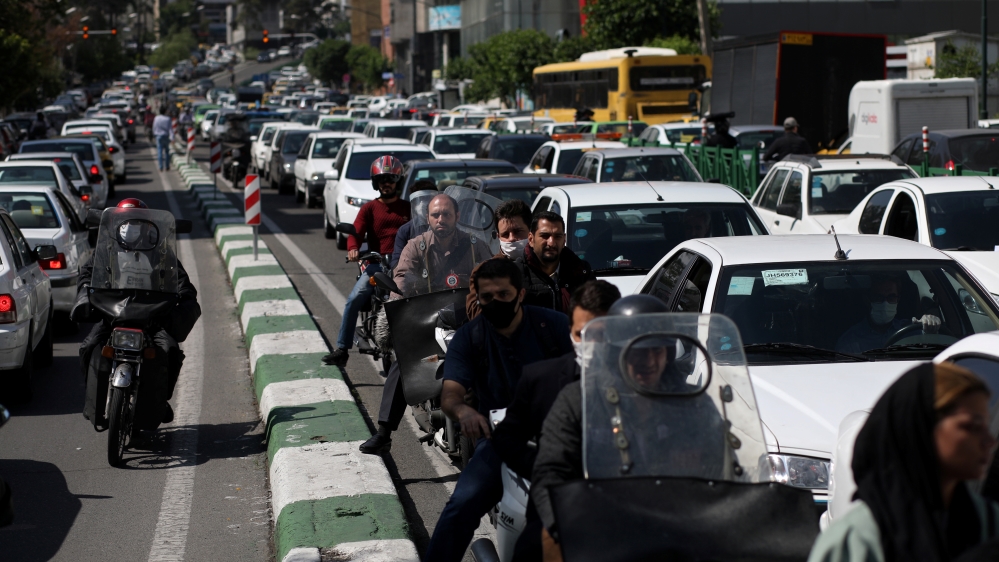 Iranians wear protective face masks, following the outbreak of the coronavirus disease (COVID-19) as they ride on their motorbikes in a crowded street, in Tehran, Iran