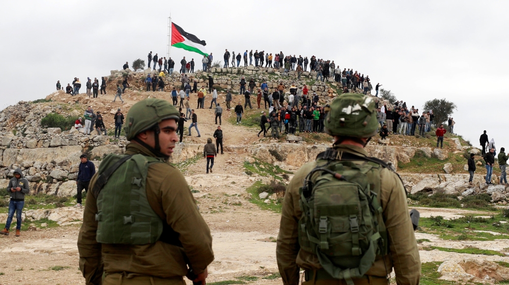 Israeli soldiers stand guard as Palestinian demonstrators gather during a protest against Israeli settlements in Beita town near Nablus in the Israeli-occupied West Bank March 2. REUTERS/Mohamad