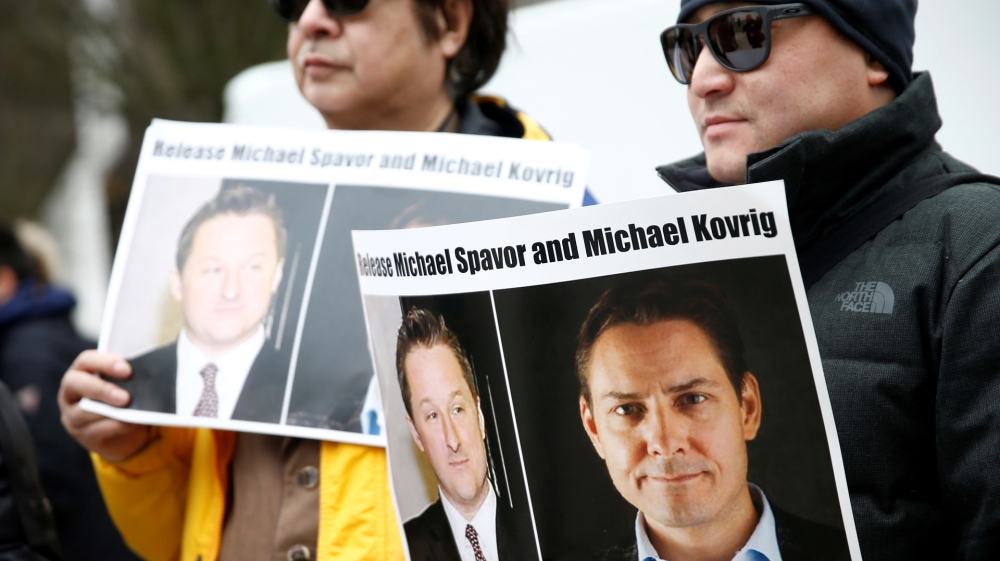 eople hold signs calling for China to release Canadian detainees Spavor and Kovrig