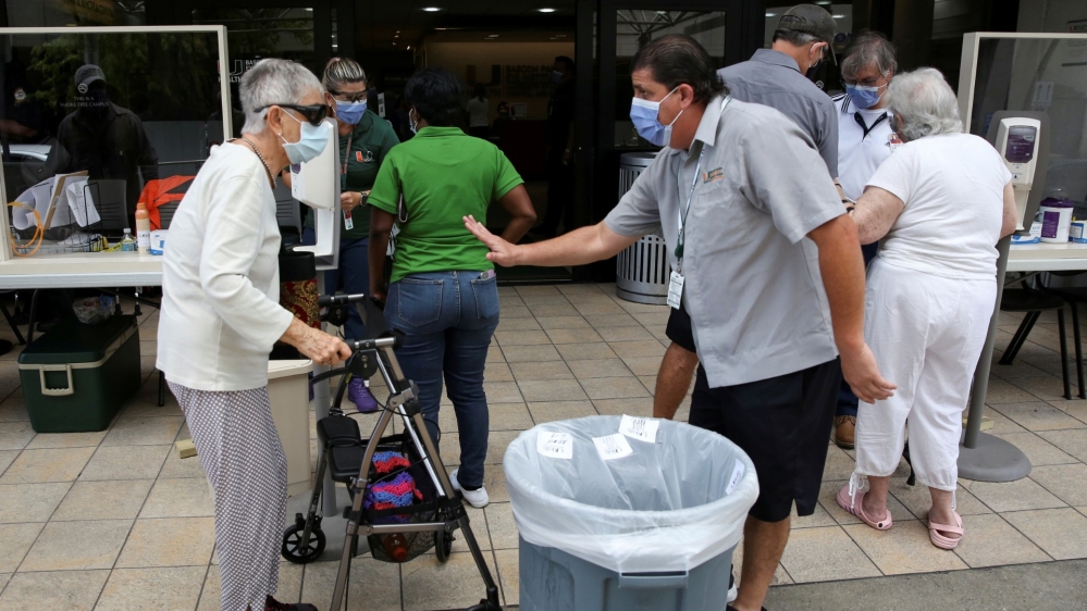 People wait for a health assessment check-in before entering Jackson Memorial Hospital, as Miami-Dade County eases some of the lockdown measures put in place during the coronavirus outbreak, in Miami, Florida