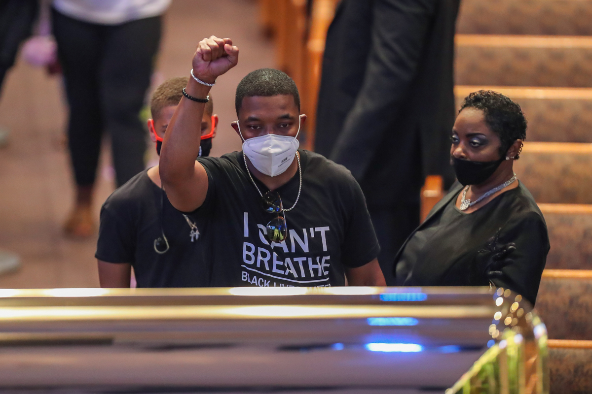 epa08473813 A man raises his fist as he views the casket of George Floyd during a public visitation for George Floyd at the Fountain of Praise church, in Houston, Texas, USA, 08 June 2020. A bystander