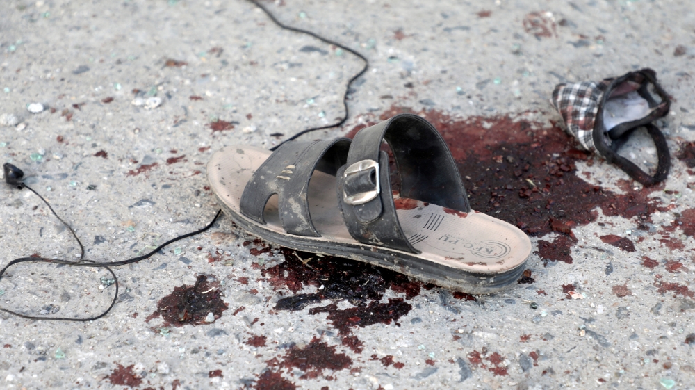 A sandal and bloodstain are seen near a bus which carried employees of an Afghan television station and was bombed, in Kabul