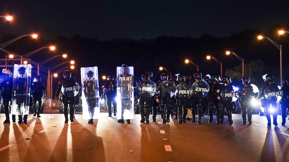 Police with riot shields advance to detain protesters for blocking traffic on a freeway during a rally against racial inequality and the police shooting death of Rayshard Brooks, in Atlanta, Georgia, 