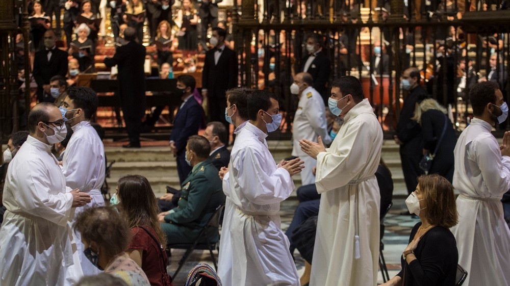Priests walk past relatives during a memorial mass for the COVID-19 victims officiated at the cathedral of Seville, on June 4, 2020; hundreds of people who lost loved ones to the virus joined a huge funeral mass at Seville Cathedral in one of the largest public gatherings in Spain since the lockdown