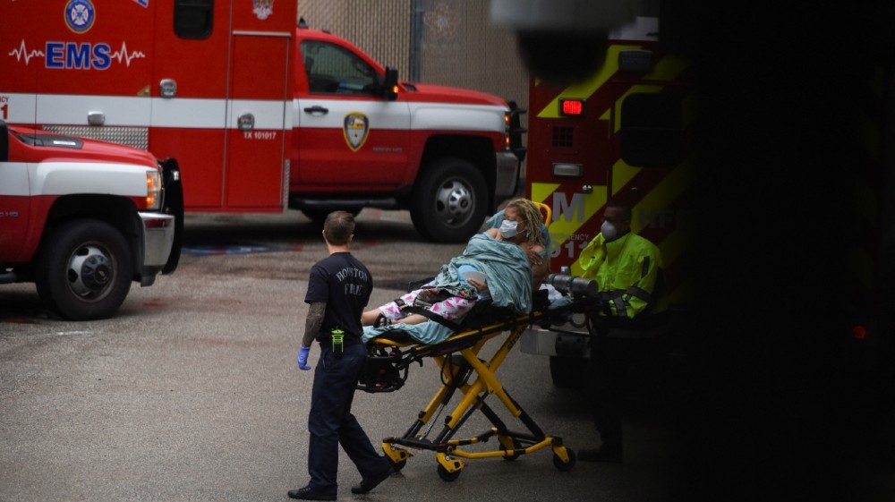 A patient is wheeled into Houston Methodist Hospital as storm clouds gather over the Texas Medical Center, amid the global outbreak of the coronavirus disease (COVID-19)