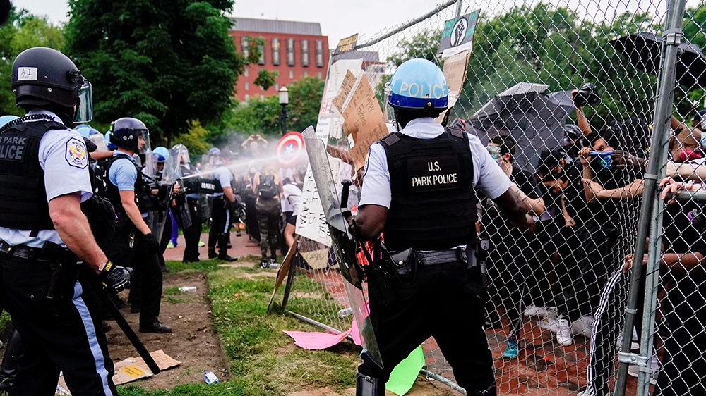 U.S. Park Police officers deploy pepper spray as they clash with protestors during an attempt to pull down the statue of U.S. President Andrew Jackson in the middle of Lafayette Park in front of the W