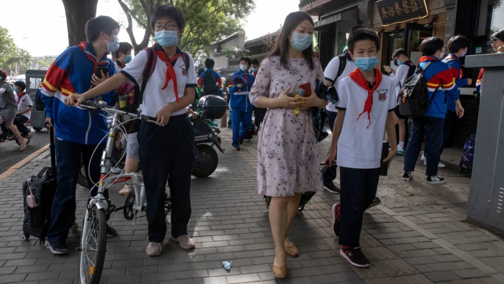 Students wearing masks to curb the spread of the new coronavirus leave after the end of a school day in Beijing on Wednesday