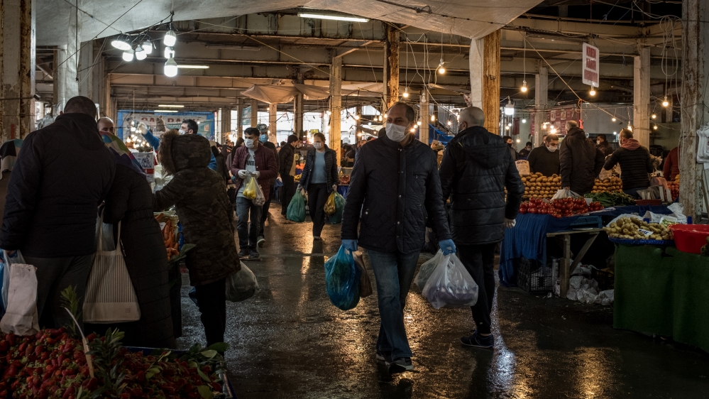 People wear masks as they shop for fruit and vegetables at the Besiktas market in Istanbul