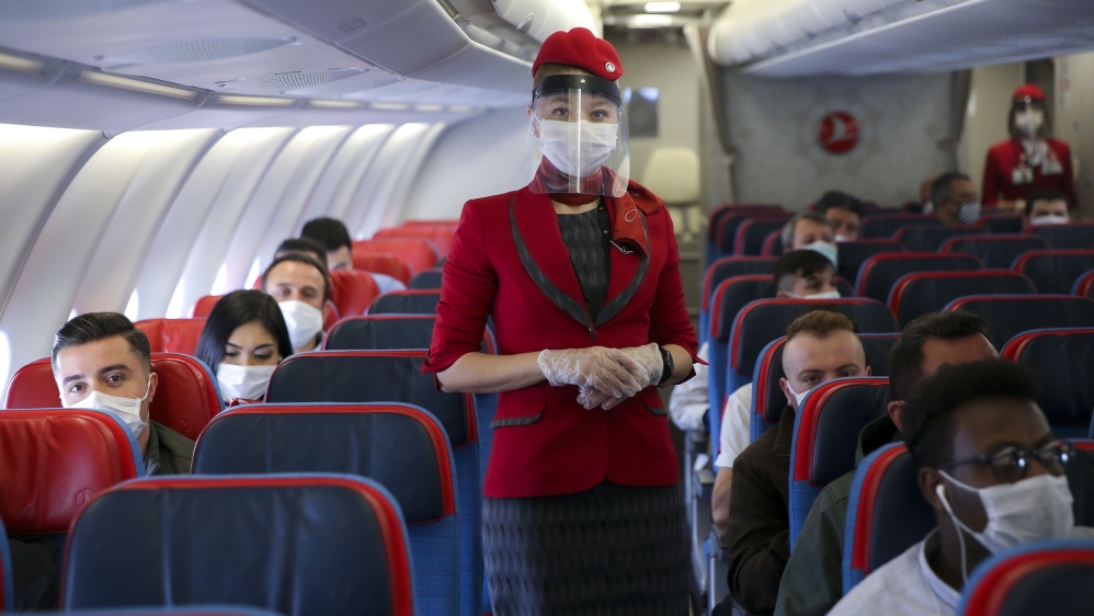 Stewardess and travelers wearing face masks onboard the first flight from Istanbul to Ankara as intercity travel resumes