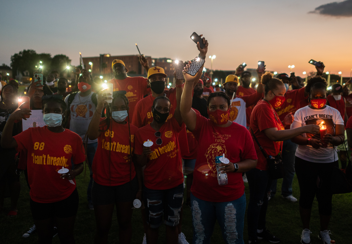 Visitors hold their lit phones as they pay their respects to George Floyd during a candlelight vigil at Jack Yates High School in Houston, Texas on June 8, 2020. - George Floyd, the 46-year-old Africa