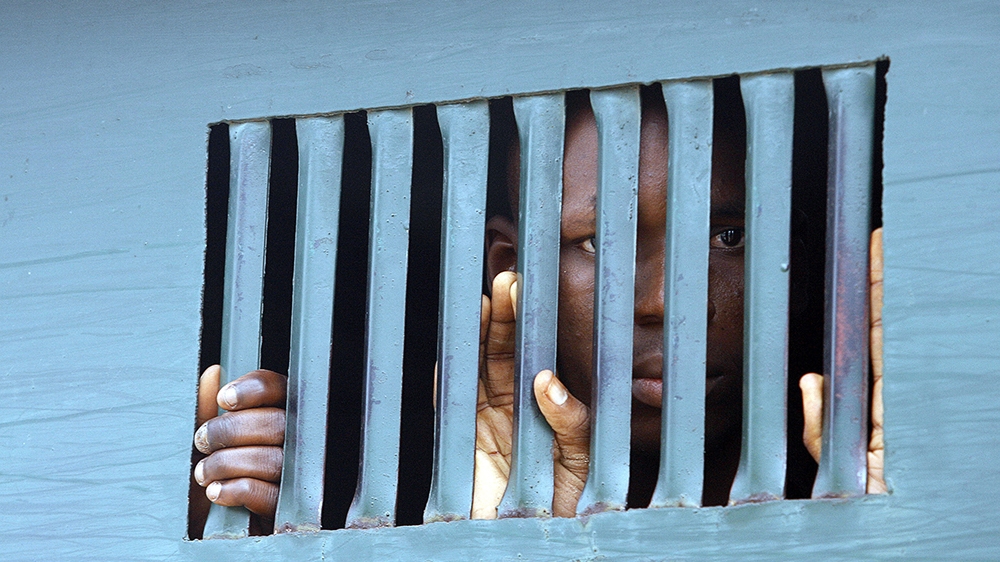 A man waits to be taken to prison after a court hearing in Nigeria