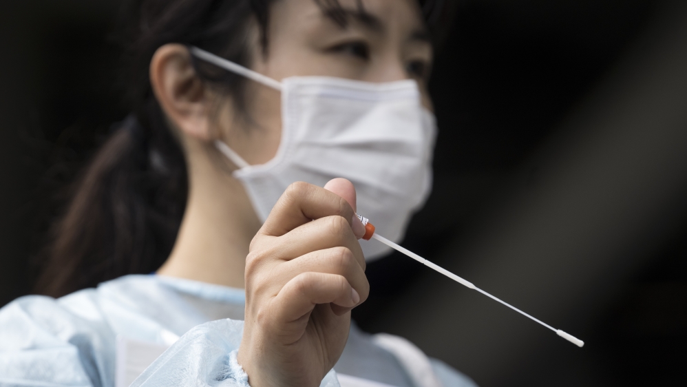 A medical staff member holds a cotton swab for a COVID-19 polymerase chain reaction (PCR) test during a rehearsal at a testing site outside Kashima Soccer Stadium on May 10, 2020 in Kashima, Japan