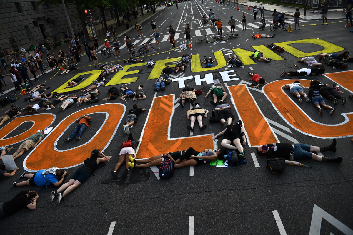 Demonstrators lie on the pavement during a peaceful protest against police brutality and racism, on June 6, 2020 in Washington, DC. - Demonstrations are being held across the US following the death of