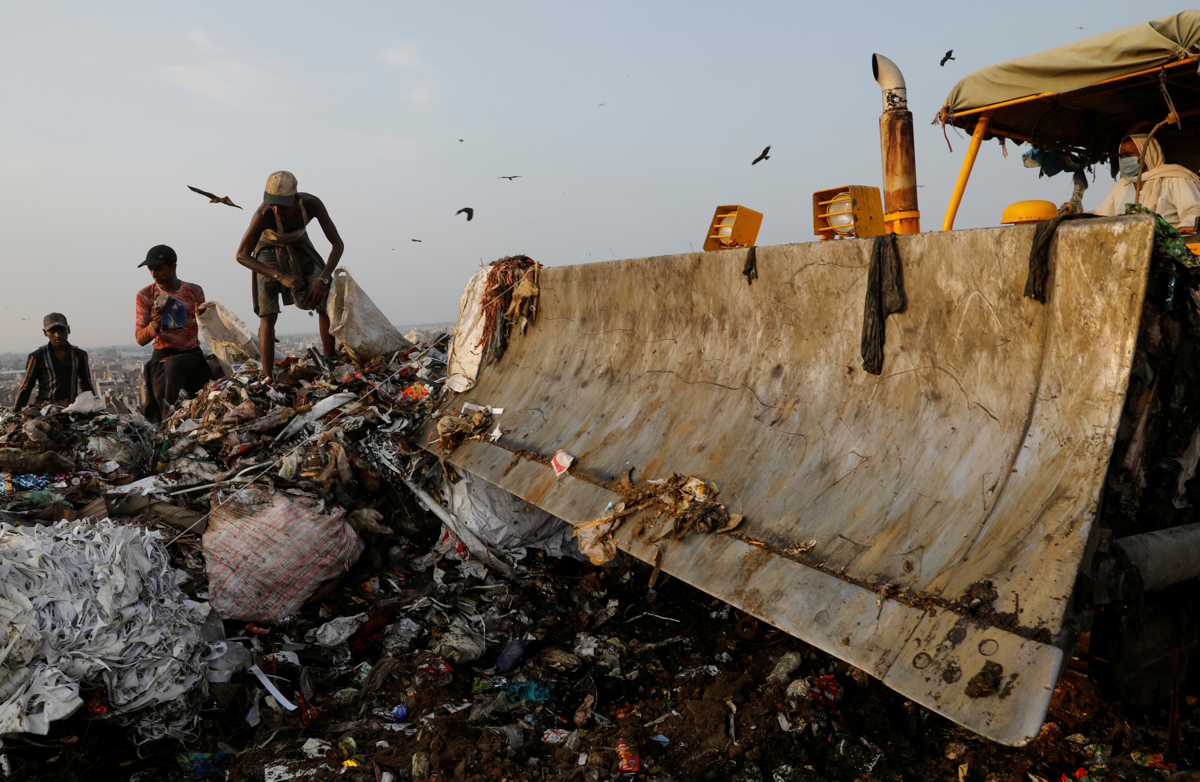 Waste collectors look for recyclable materials at a landfill site, during the coronavirus disease (COVID-19) outbreak, in New Delhi, India, July 9, 2020. REUTERS/Adnan Abidi SEARCH "COVID-19 MEDIC
