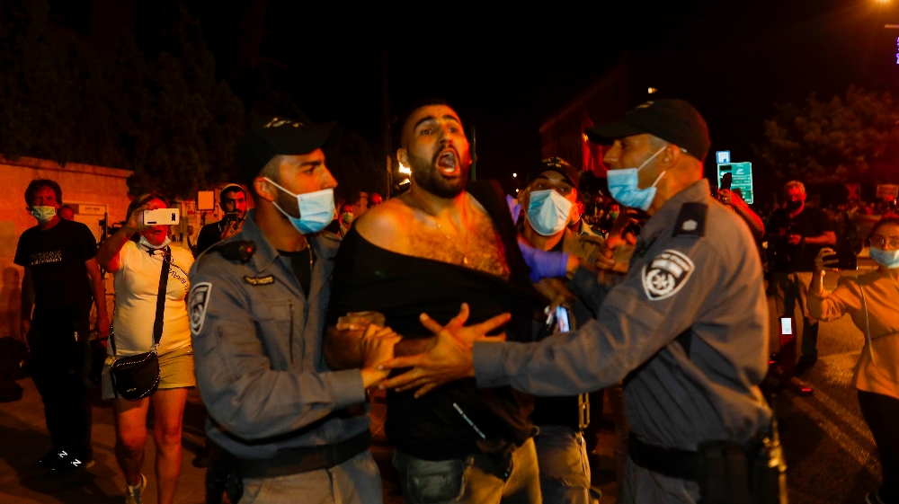 ISRAEL-POLITICS-PROTEST  A protester is detained by Israeli police during a demonstration against Israeli Prime Minister Benjamin Netanyahu outside his official residence in Jerusalem