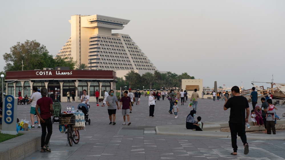 People walk on Doha's corniche as Qatar enters phase two of easing coronavirus  restriction [Sorin Furcoi/Al Jazeera]