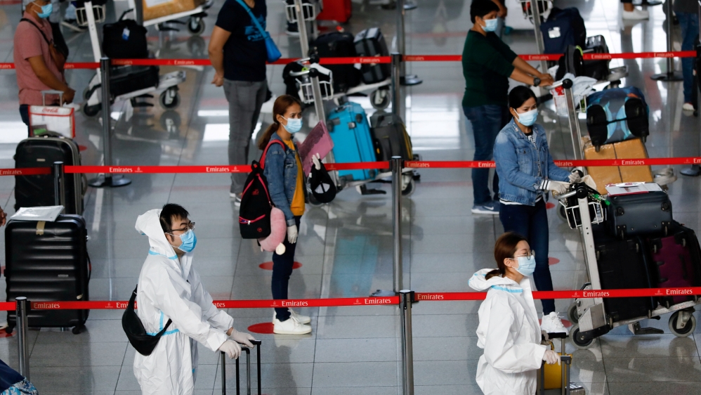 Passengers wearing personal protective equipment for protection against COVID-19 queue at the check-in counters in Ninoy Aquino International Airport in Pasay City, Metro Manila