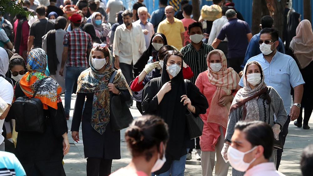 Iranians wearing face masks go shopping around Tehran’s grand bazaar in Tehran