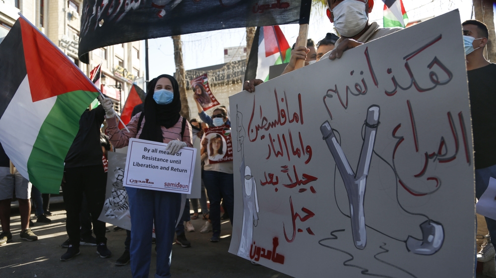 Palestinians demonstrate against Israeli plans for the annexation of parts of the West Bank, in the in the West Bank city of Ramallah, Wednesday, July 1, 2020.The Arabic reads : " This is how we under